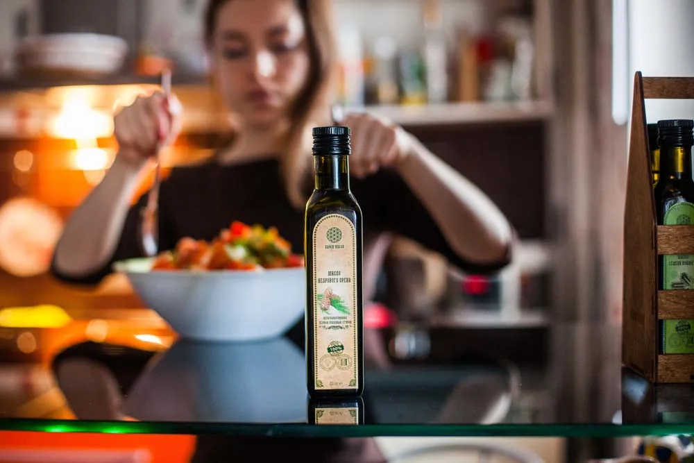 Кухня женщина заправляет салат маслом кухне дой
